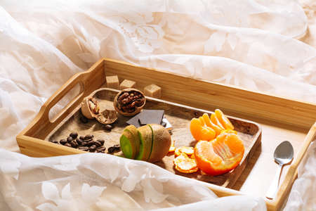breakfast in bed with fruits and nuts on a tray. Orange, kiwi, coffee beans breakfastの写真素材