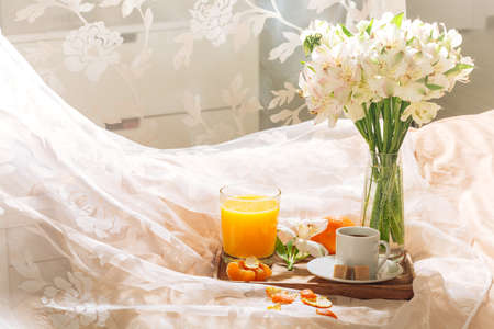 breakfast in bed with fruits, coffee and flowers on a tray. Romantic breakfast in bedの写真素材