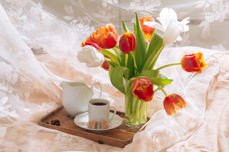 breakfast in bed with coffee and flowers tulips on a tray. Romantic breakfast in bed.の写真素材