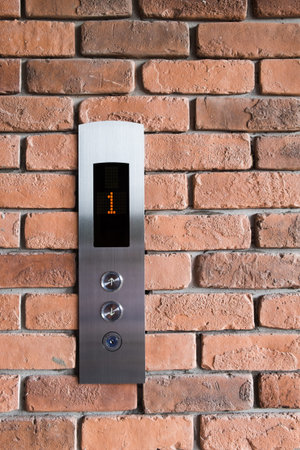 Lift elevator panel on brick wall