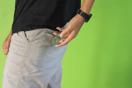 Man with hand sanitizer in her pocket pantsの写真素材