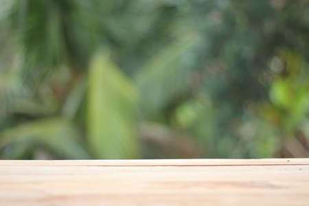 Empty table board and green fresh blured backgroundの写真素材