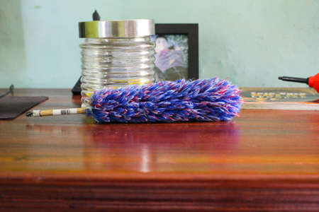 Feather duster and jar on tableの写真素材