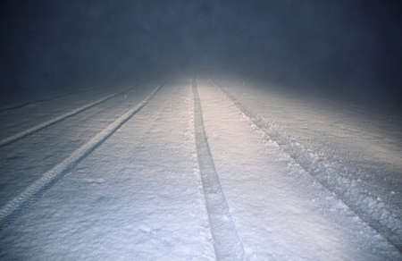 Directing lines of the tires. Night fog. Snowy field.の写真素材