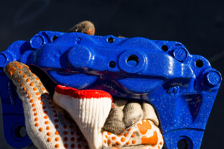 Blue 4 pot brake caliper un hand of car mechanicの写真素材