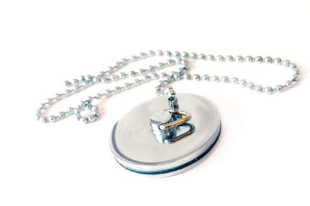 An image of a silver bath-plug isolated on white. Shallow depth of field used as main focus area is the plug itself.の写真素材