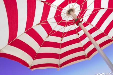 Section of beach umbrella against blue sky.の写真素材
