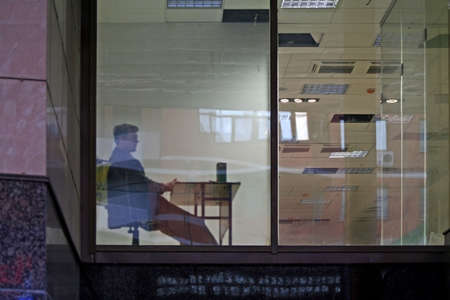 View on a window of the unknown company in the late evening at the end of the working day.の写真素材