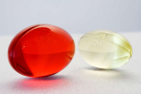 Two medical capsules on the white fabric surface.の写真素材
