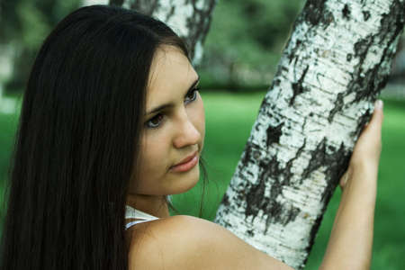 The beautiful girl relaxs in a birchwood.の写真素材