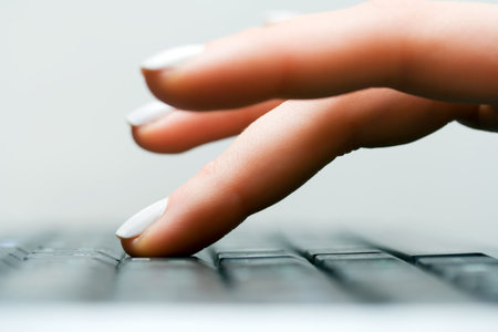 Female hand typing on keyboard.