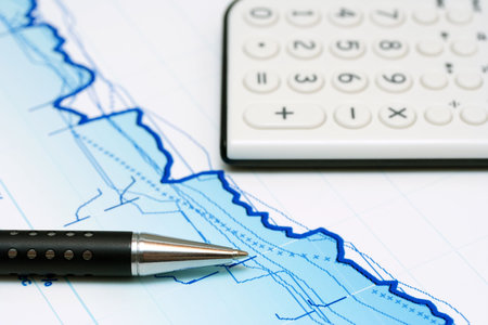 Calculator, pen and stock index reports.