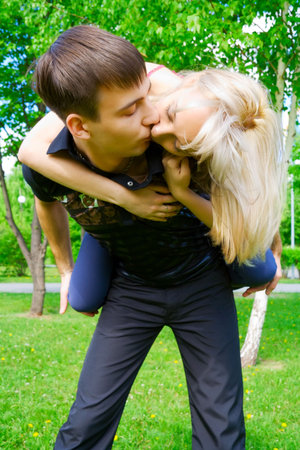 Happy young couple kissing on nature.