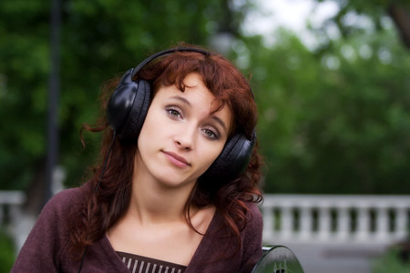 Sad young woman listening to music.
