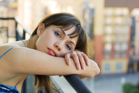 Thoughtful woman on a balcony of a house.