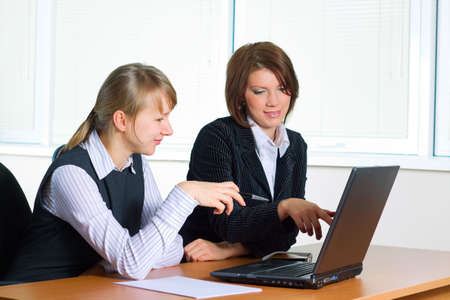 Two young businesswoman working on the laptop.の写真素材