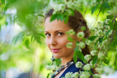 Beautiful woman among blossoming trees.