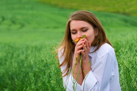 Happy young woman and wild flowers.の写真素材