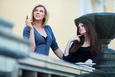 Two young female students on campus.の写真素材