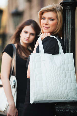 Two young women walking on a city street.の写真素材