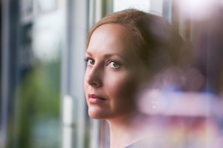 Beautiful woman looking through the window