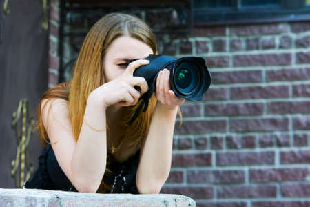 Young woman holding a digital photo cameraの写真素材