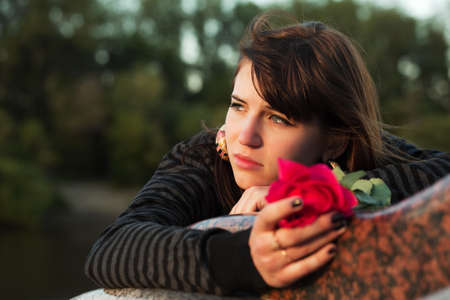 Sad young woman with a red roseの写真素材