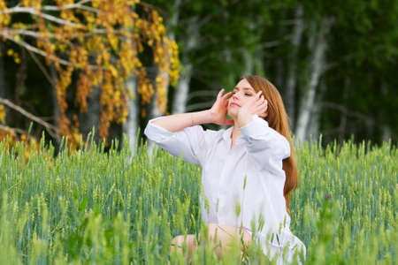 Young woman sitting in a grassの写真素材