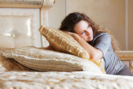 Beautiful woman leaning on the pillowsの写真素材