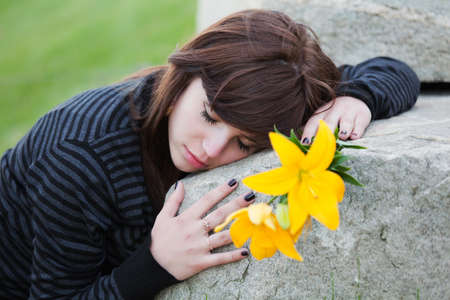 Young woman lying on the tombstoneの写真素材