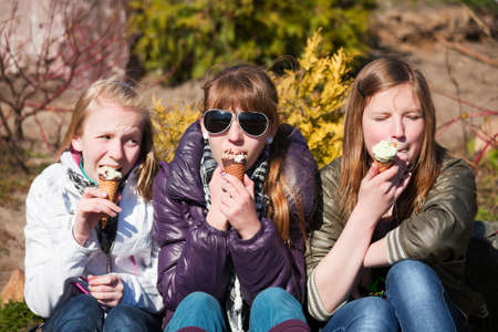 Teenage girls eating an ice creamの写真素材