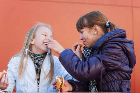 Two girls eating a burgersの写真素材