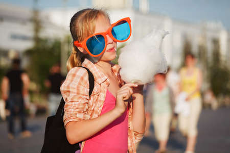 Girl eating cotton candyの写真素材