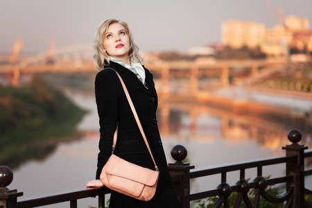 Young woman against autumn urban backgroundの写真素材