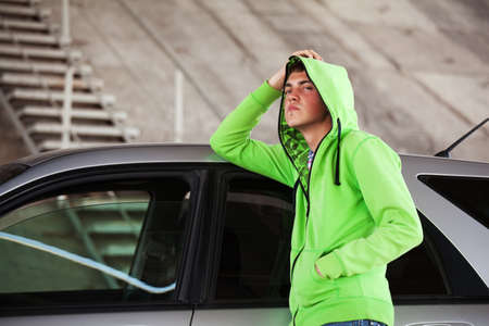 Young man standing against a carの写真素材