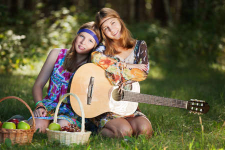 Hippie girls with a guitar outdoorの写真素材