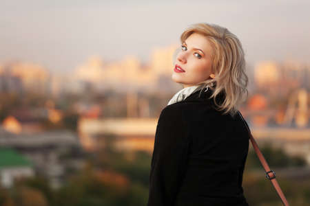 Young woman against autumn urban backgroundの写真素材