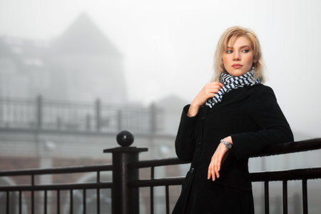 Young woman in autumn foggy morningの写真素材