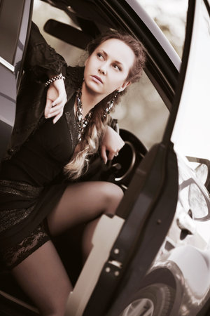Beautiful woman sitting in a sports carの写真素材