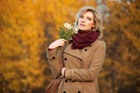 Young woman with a flowers in autumn forestの写真素材