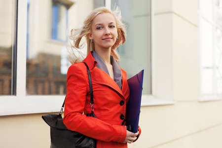 Young businesswoman with a folder against office windowsの写真素材