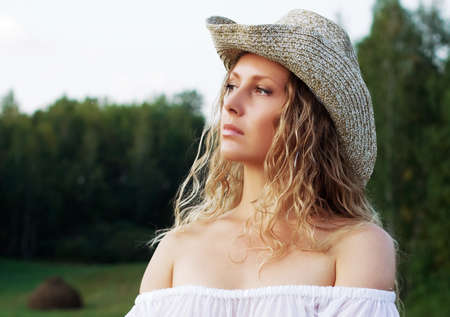 Beautiful young woman walking in a fieldの写真素材