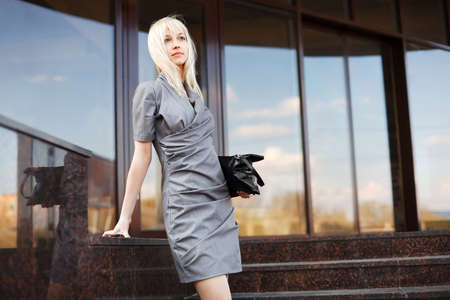 Young businesswoman on the steps against office windowsの写真素材