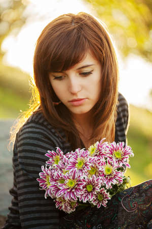 Sad young woman with a flowersの写真素材