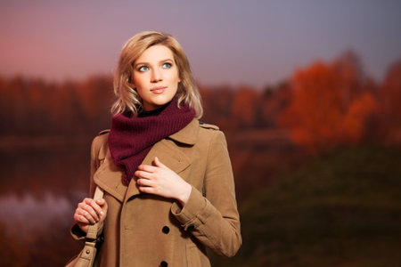 Young blond woman against an autumn nature backgroundの写真素材