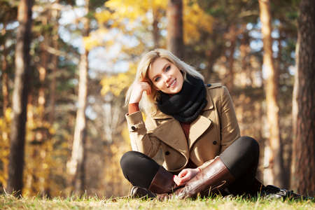 Happy blond woman in autumn forestの写真素材