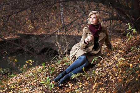 Young blond woman in autumn forestの写真素材