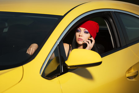 Young woman calling on cell phone in a carの写真素材