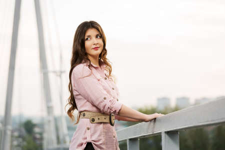 Happy young woman standing on the bridgeの写真素材