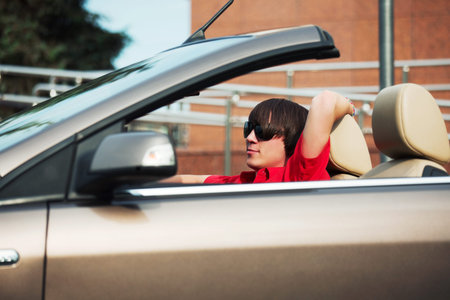 Young man driving a convertible carの写真素材